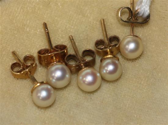 Two pairs of gold and cultured pearl ear studs and one other single ear stud.